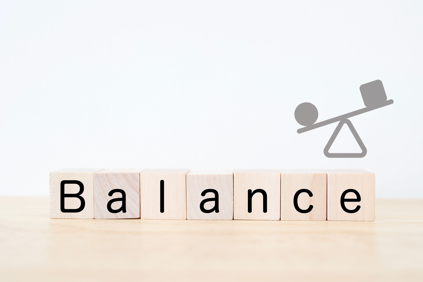 外部サービスと自炊のバランスを示す木製ブロックとシーソーのイメージ