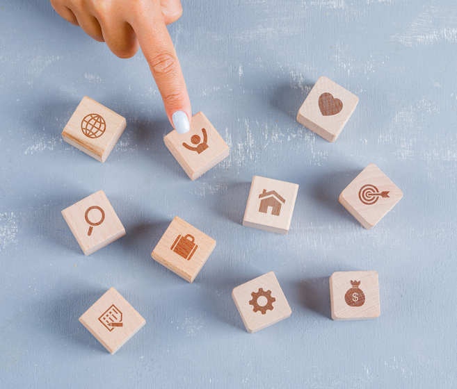 複数の選択肢から1つを選ぶ手元と木製アイコンブロック