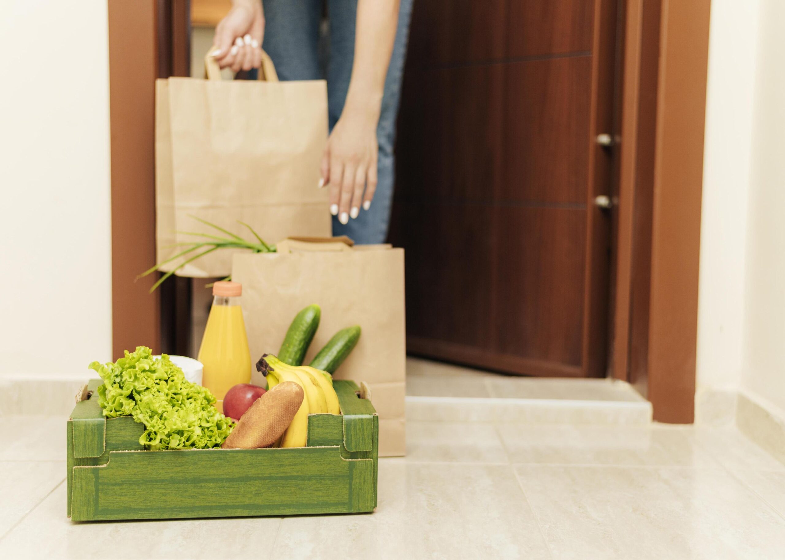 自宅に届いた食材宅配のボックスを受け取る様子