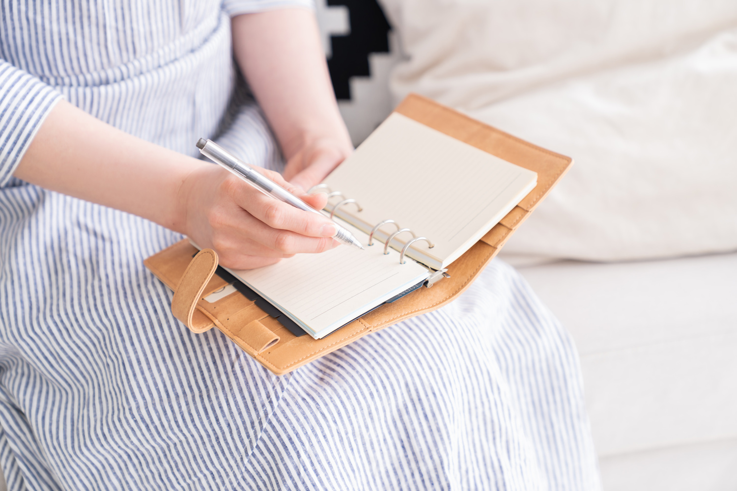 ノートを開き、ペンで予定や計画を書き込んでいる手元の様子